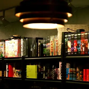 店内は海外のボードゲームやアイロンビーズが並ぶ遊び心あふれる空間。国際交流を楽しめる雰囲気で、学生や女性客にも人気です。人狼専用の個室や２２１色のアイロンビーズ体験、ボードゲームの遊び放題プランなど、仲間とゆったり楽しめる要素が満載。最高の冒険が待つ空間で、特別なひとときをお過ごしください。