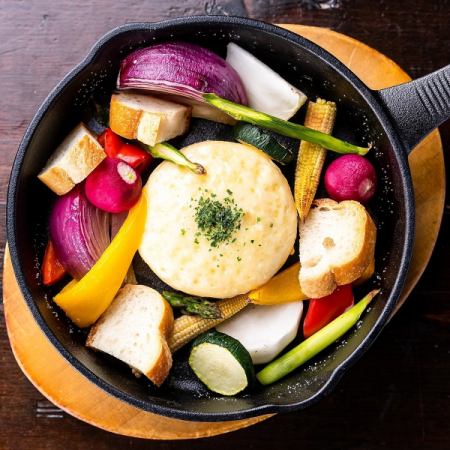 Cheese fondue with colorful seasonal vegetables and roasted camembert
