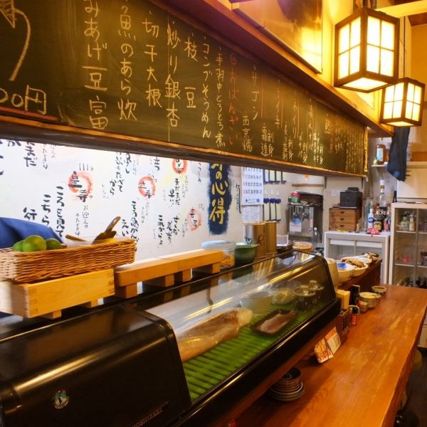 柜台上方的黑板上写着当天推荐的鱼和当天的八字菜。一个受欢迎的座位，您可以在与店员聊天的同时喝酒。