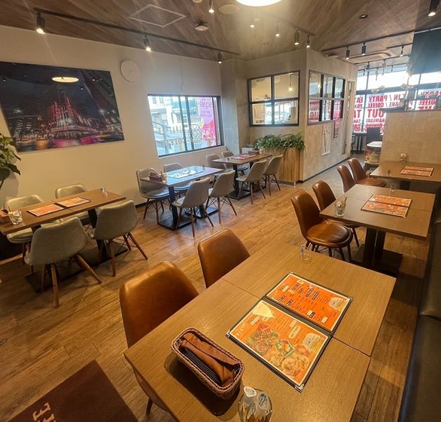 【広々としたお洒落な店内】ウッド調の落ち着いた雰囲気のお洒落な店内は広々としたテーブル席をメインにご用意しております。テーブルの片側はソファー席になっているので、ゆったりとお寛ぎいただけます。また、店内には音響設備やプロジェクターのご用意もございます。