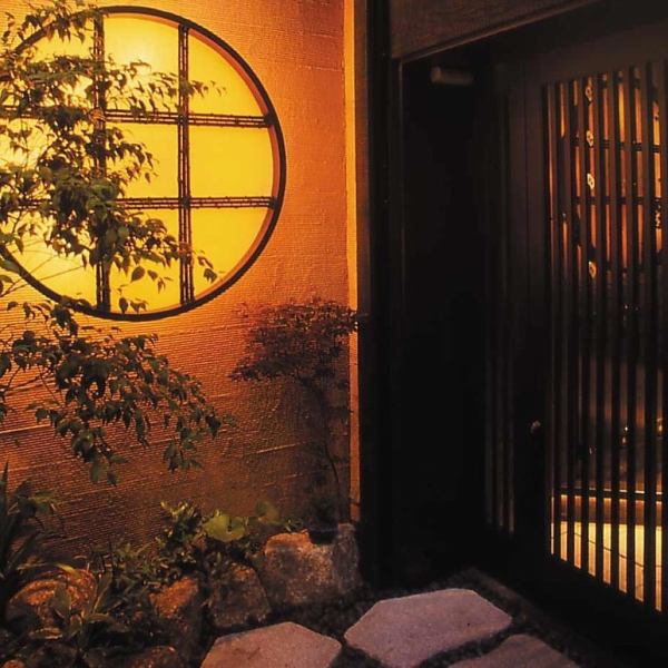 丸格子の照明、坪庭、竹林、石畳。玄関は格調高く、それでいてほっこり安らぐ和の佇まい