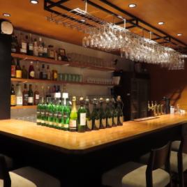 ワイングラスホルダーが圧巻な店内中央のカウンター席。本格的なバーカウンターは雰囲気たっぷり。