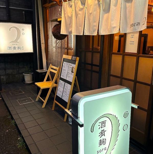 シンプルで洗練された外観が印象的なお店。暖簾がかかった入り口は温かみを感じさせ、明るい看板が訪れる人を引き寄せます。落ち着いた雰囲気の店内にはカウンター席と座敷席が用意されております。