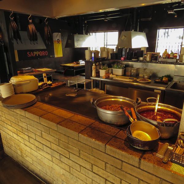 店内中央にオープンキッチンあり。特大の鉄板で調理する様子をお楽しみ下さい！