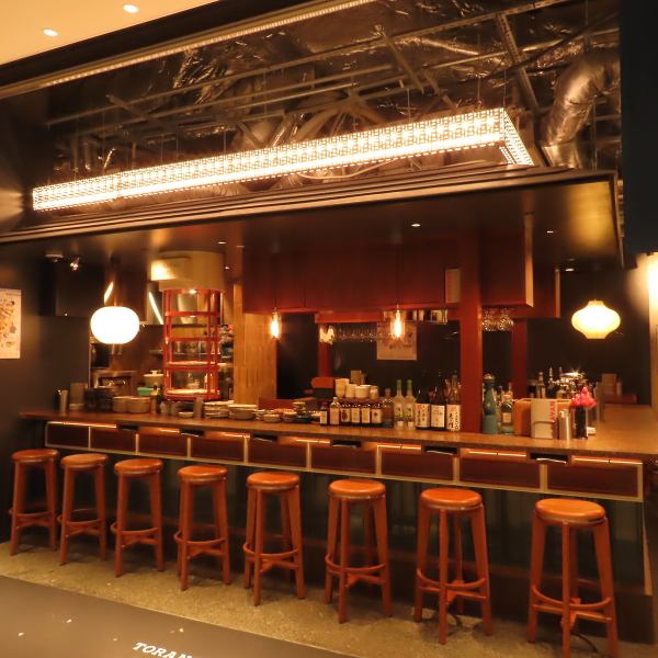 当店のカウンター席は、横丁の賑わいを間近に感じられる特等席。椅子は「CARAVAN」をイメージし、横丁スタイルに合わせて高さやロゴまでこだわり抜いた特注品。実は、便利な荷物カゴ付きで、身軽にゆったりとお過ごしいただけます。試行錯誤を重ねたオールインワンチェアで、ここだけの特別な時間をお楽しみください。