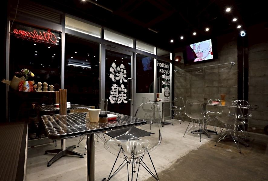 【テーブル席:2名様~6名様】無骨なコンクリートブロックの壁が印象的なテーブル席は、インダストリアルな雰囲気が漂います。スタイリッシュなクリアチェアとメタル素材のテーブルが、都会的で洗練された空間を演出。友人や同僚との食事に最適な、広々とした配置です。