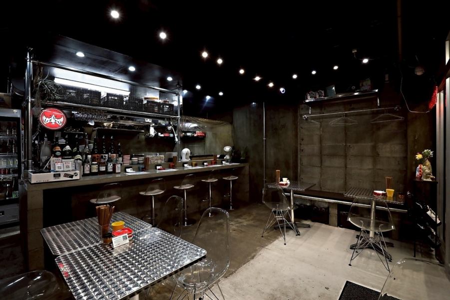 【テーブル席:2名様~6名様】インダストリアルな要素を取り入れた奥のテーブル席は、落ち着いた雰囲気の中で食事を楽しみたい方に最適です。コンクリートの壁とメタル素材のテーブルが調和し、洗練された空間を演出。ベンチシートもあり、ゆったりと過ごせます。