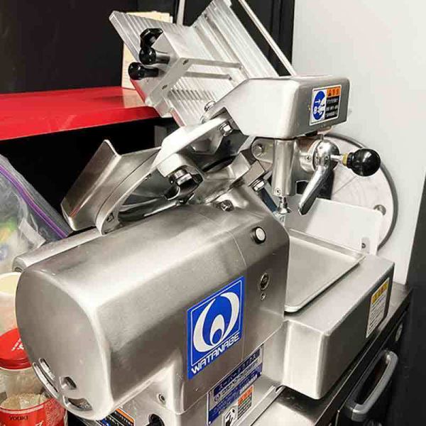 大型業務用スライサー。超薄切り牛タンは手切りでは均等かつ1mmという超薄切りは不可能なため店内業務用スライサーでスライスしています。タン刺しでも召し上がれる和牛超薄切り牛タンです。サーロインの焼きしゃぶやすき焼き風焼肉なども絶妙な厚みでスライスしています。