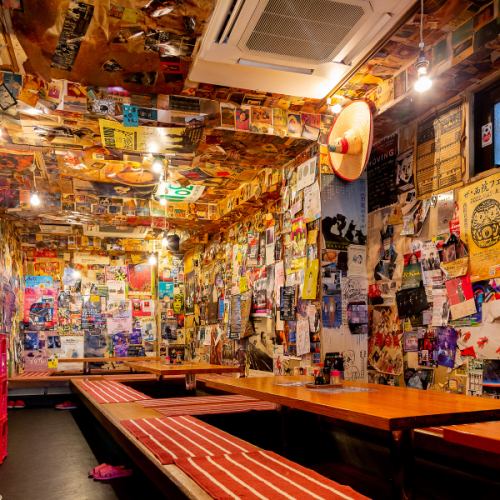 こちらは1階です！暖かな照明と遊び心が詰まった、こだわりのインテリアの中、お連れ様との時間をお楽しみください！壁だけでなく、天井にも切り抜きや写真がいっぱい♪お料理の待ち時間には懐かしい写真、お気に入りの切り抜きを見つけてみてはいかがでしょうか？