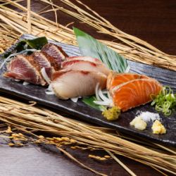 Assortment of three kinds of fresh fish grilled over straw