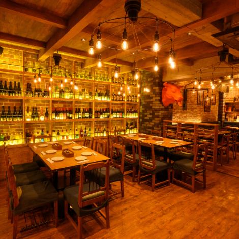 レンガ風の壁が温かみと味わいを演出し、壁に並ぶお酒がアクセントとなっています。木目調を基調とした内装は落ち着いた雰囲気を醸し出し、明るい照明が心地よさを演出しています。おしゃれでアットホームな雰囲気です♪