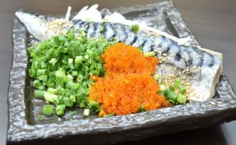 Broiled mackerel covered in green onions and sesame seeds