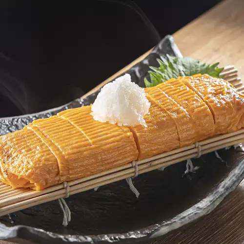 鉄板で巻き上げる「鉄板出汁巻き」は出汁の旨みと香ばしい焼き目が魅力。熱々で提供いたします！