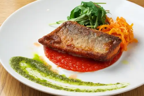 Pan-fried domestic salmon with a double sauce of tomatoes and basil.