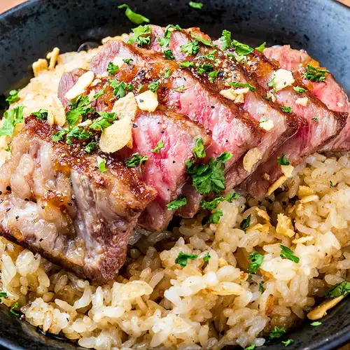 Garlic rice topped with beef steak