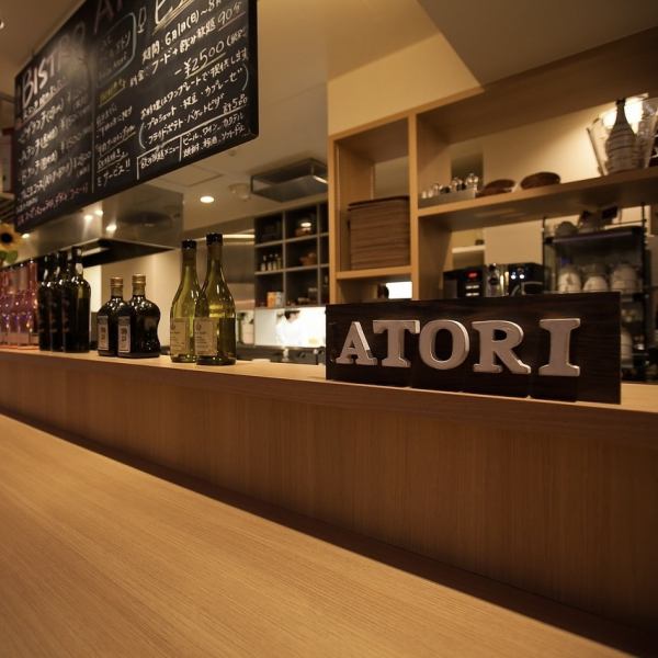 街の喧騒の中に隠れた「大人の遊び場」のビストロアトリ。オープンキッチンで居心地のいい店内は、まさにヨーロッパの風香る空間です。店内にはシックなシャンデリアもあり、特別な空間を演出。