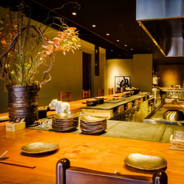 【カウンター席】鉄板焼きならではの臨場感が目の前でお楽しみ頂ける人気のお席。黒を基調とした落ち着きのある店内。間接照明がやさしく照らす店内は、ゆっくりとお食事を楽しんでいただけるようデザイン致しました。デートや大切な友人と楽しむのにぴったり！おすすめのお料理やお酒など気軽にお尋ね下さい。