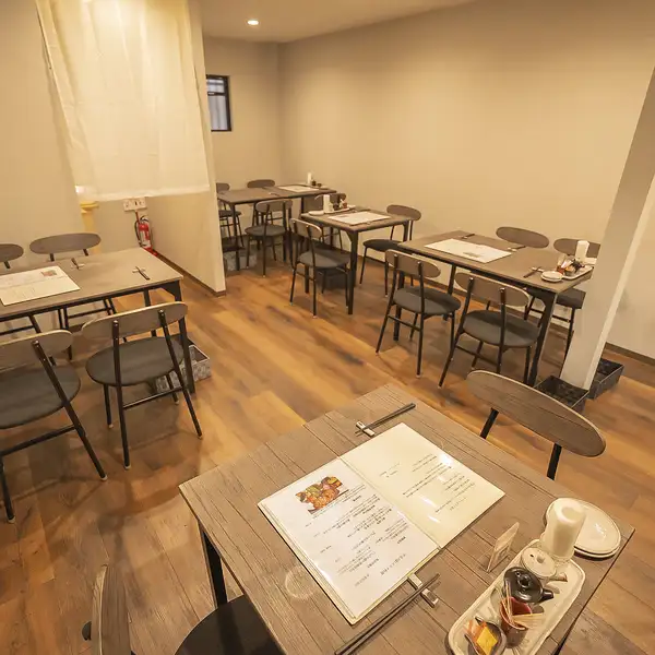 木目を基調とした店内は、清潔感と温もりが感じられる落ち着いた空間。テーブル席は程よい間隔で配置されており、ゆったりと食事が楽しめます。ファミリーや女子会、友人同士の食事など幅広い利用シーンに対応可能です。
