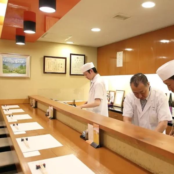 【カウンター席】料理人の技を身近で楽しめる特別席です！カウンター8席は、お酒が並ぶ背景と料理人の手仕事を目で楽しむことができます。プロのおもてなしを体験し、その場で料理に合う日本酒を提案。おいしさのあまり飲みすぎにはご注意ください。