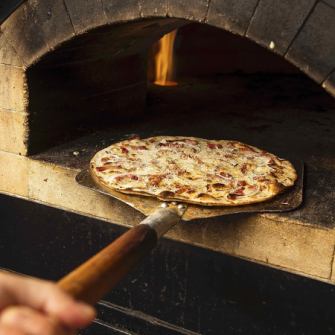 窯で焼き上げるフランス・アルザス地方のピザ『タルトフランベ 』