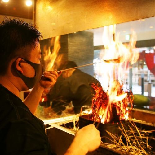 Our specialty [straw-grilled dish] finished with a dynamic flame