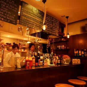 カウンター席は、オレンジの照明が優しく照らす温かい空間です。目の前でドリンクを作ってくれるシェフとの距離感も心地よく、木の温かみが安らぎを与えます。肩を並べて、大切な人との特別なひとときを楽しむのにぴったりの場所です。リラックスした雰囲気の中で、心温まる会話と美味しい料理をお楽しみください。