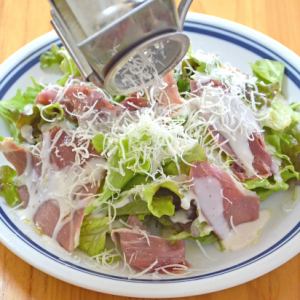 Caesar salad with freshly grated cheese and prosciutto