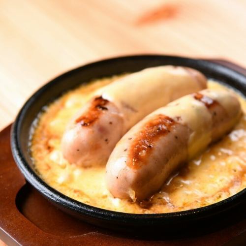 Giant sausage on an iron plate with cheese