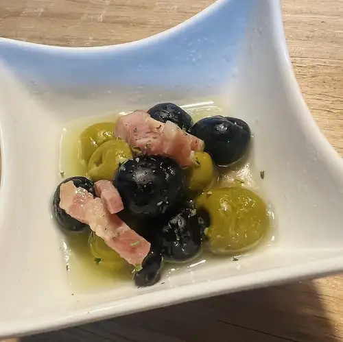 ニンニクとハーブで煮込んだベーコンとオリーブのマリネ