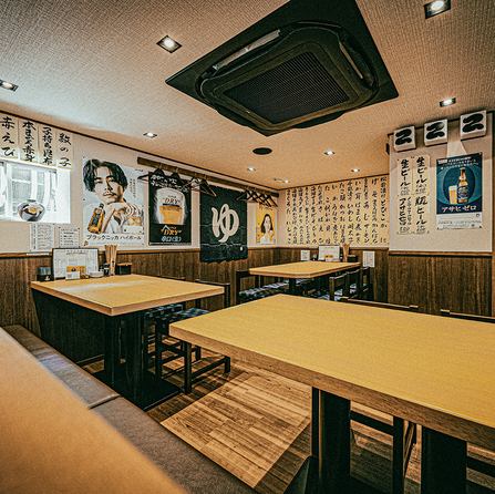 落ち着いた雰囲気の店内は、シンプルで清潔感のあるテーブル席が並び、壁には和風の書やメニュー、ポスターが飾られています。柔らかな照明が心地よく、カジュアルながらも上質な空間を演出。グループ利用や宴会、女子会にもぴったりで、ゆったりと食事を楽しめる設計です。