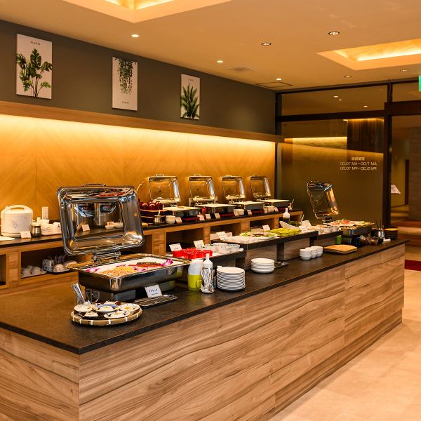 温かい照明が心地よい、ホテル内のビュッフェ♪木目調のインテリアと壁の植物アートが魅力的です。ゆとりある店内は開放感があり、どなたでも快適にお過ごしいただけます◎