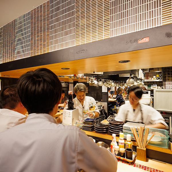 おひとり様からデートなどに使えるオープンキッチンのカウンターでは、美味しい料理とお酒で、お連れ様やナミヨセ2117の元気と活気あふれるスタッフとの会話で盛り上がること間違いないです！【金山 居酒屋 女子会 デート 宴会 飲み放題 忘年会 歓送迎会 海鮮 お肉 焼き鳥 レモンサワー 焼酎 日本酒 カウンター 個室 貸切】