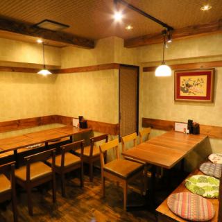 テーブル席は木の質感と間接照明が生み出す落ち着いた雰囲気が特徴。友人同士の食事や軽い飲み会にもぴったりです。