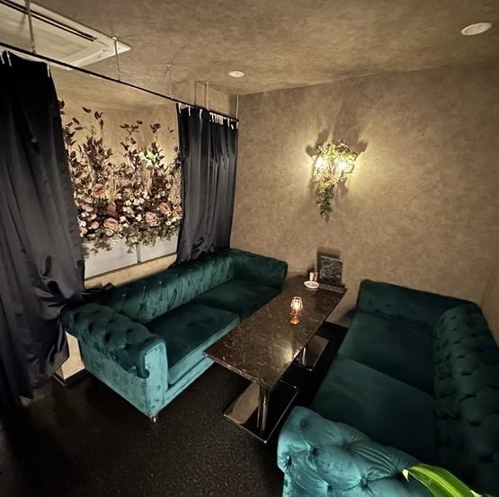 【ソファー席】落ち着いたオシャレな雰囲気が漂う空間です。深い色合いのソファが特徴的で、ゆったりとした座り心地が心地よいひとときを提供します。壁には美しい花のアートが飾られ、優雅な雰囲気を演出します。カーテンで仕切られたお席は、友人同士や特別な人との大切な時間に最適！またフロア貸切も対応可能です。