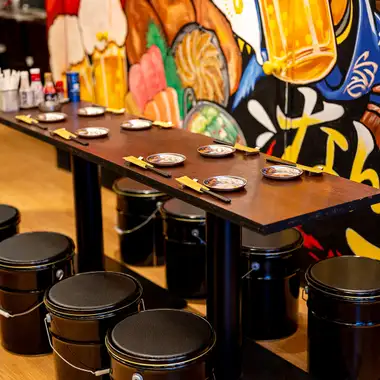 [Recreating Hakata Nakasu Yatai] Enjoy a lively atmosphere at this table seating area, perfect for banquets and drinking parties, while gazing at the giant mural that symbolizes Hakata Nakasu Yatai Village Nanshotto?The store is equipped with TV monitors, making it the perfect space for watching sports!