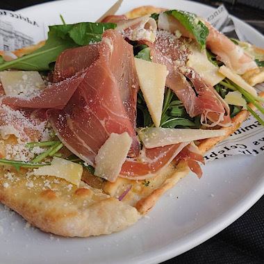 Pizza with prosciutto and rucola