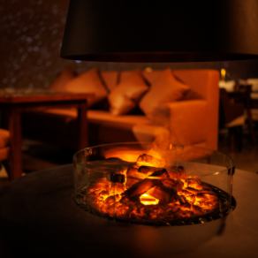 焚火のおぼろげな灯りが店内を静かに照らし、都会の喧騒を忘れさせてくれます。間接照明により心地よい明かりに包まれる空間は、日常を忘れてリラックスしたい夜に最適です。特に人気のソファ席は、ゆったりと寛げるため予約必須。揺らめく火を眺めながら、シェフ渾身の料理とともに至福の時間をどうぞ。