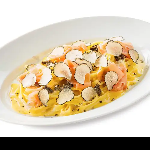 Luxurious carbonara fettuccine with black truffles and prosciutto