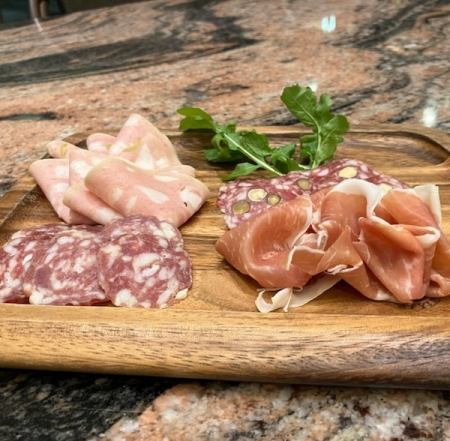 Assortment of four types of meat: prosciutto, salami, and mortadella.