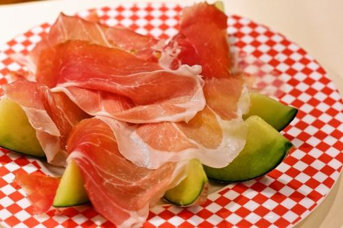 Seasonal fruits and freshly cut dry-cured ham