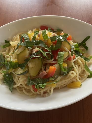 Chilled spaghetti with summer vegetables, basil and peperoncino topped with prosciutto