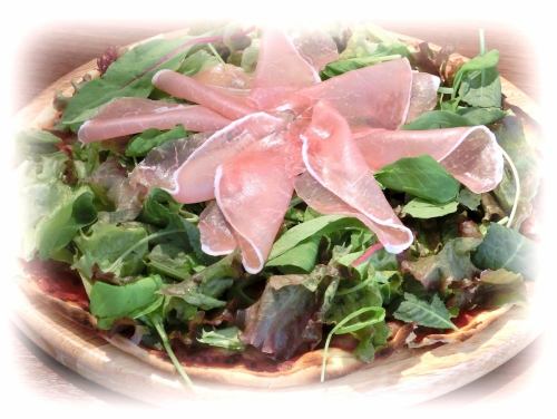 Pizza with raw ham and salad