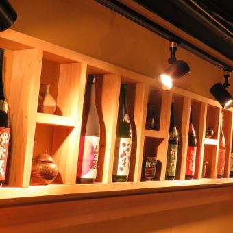 Behind the counter seats are a number of sake collections.