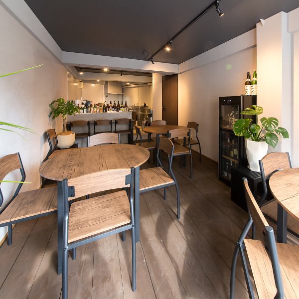 観葉植物が彩るお洒落で落ち着いた店内は、お年寄りから若い世代まで誰もが寛げる空間。一人で静かに飲めるカウンター、会話が弾む4人席（5～6人も可能）の丸テーブルはご家族で囲める広めの席を完備。15時からのハッピーアワーは、お散歩ついでにふらっと立ち寄れる開放感に満ちています。心ゆくまで贅沢なひとときを。