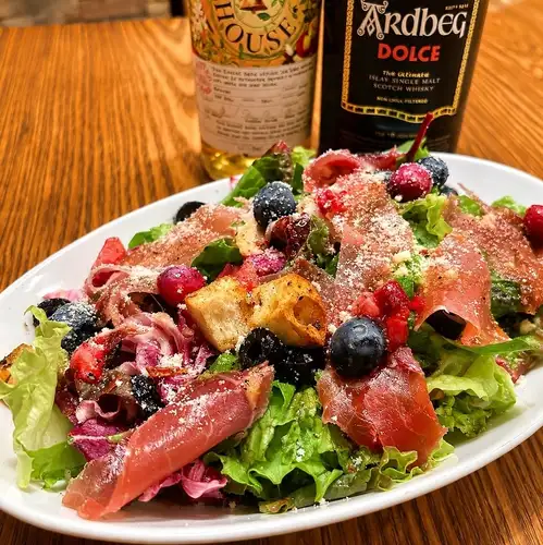 Prosciutto and colorful vegetable salad with berry vinaigrette