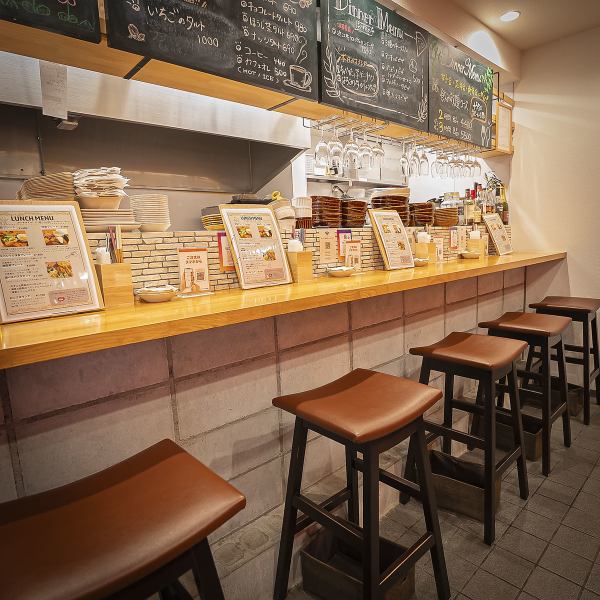 【1階:アットホームなカウンター】お一人様やカップルでのご利用に人気のカウンター席。オープンキッチンの活気を感じながら、お食事とお酒を楽しめます。気さくな雰囲気で、ふらっと立ち寄れる気軽さが魅力。お仕事帰りの一杯やサク飲みにもぜひご利用ください。
