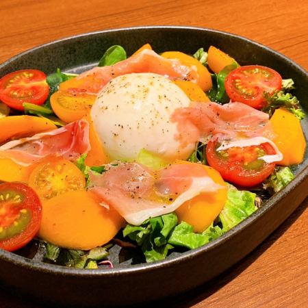 Burrata cheese with seasonal fruits, fruit tomatoes and prosciutto