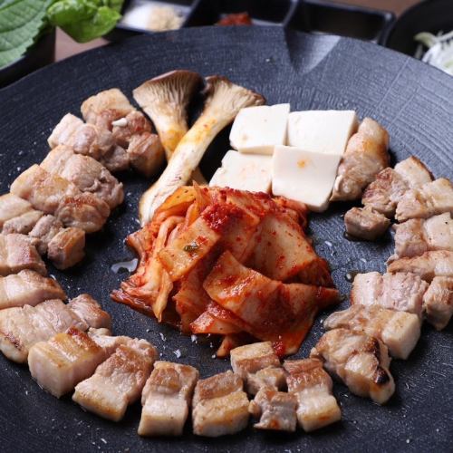 A classic Korean dish! <<Samgyeopsal>> Enjoy it with the accompanying kimchi and wrapped vegetables.