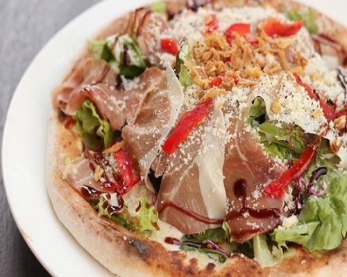Garden pizza with sunny lettuce and Italian ham