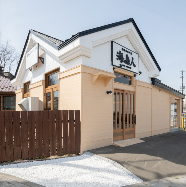 白と木目を基調とした外観は、上品で親しみやすい印象。大きな看板と落ち着いた佇まいが目を引き、初めての方でも入りやすい雰囲気です。観光やお食事の立ち寄りにも最適な店舗外観です。